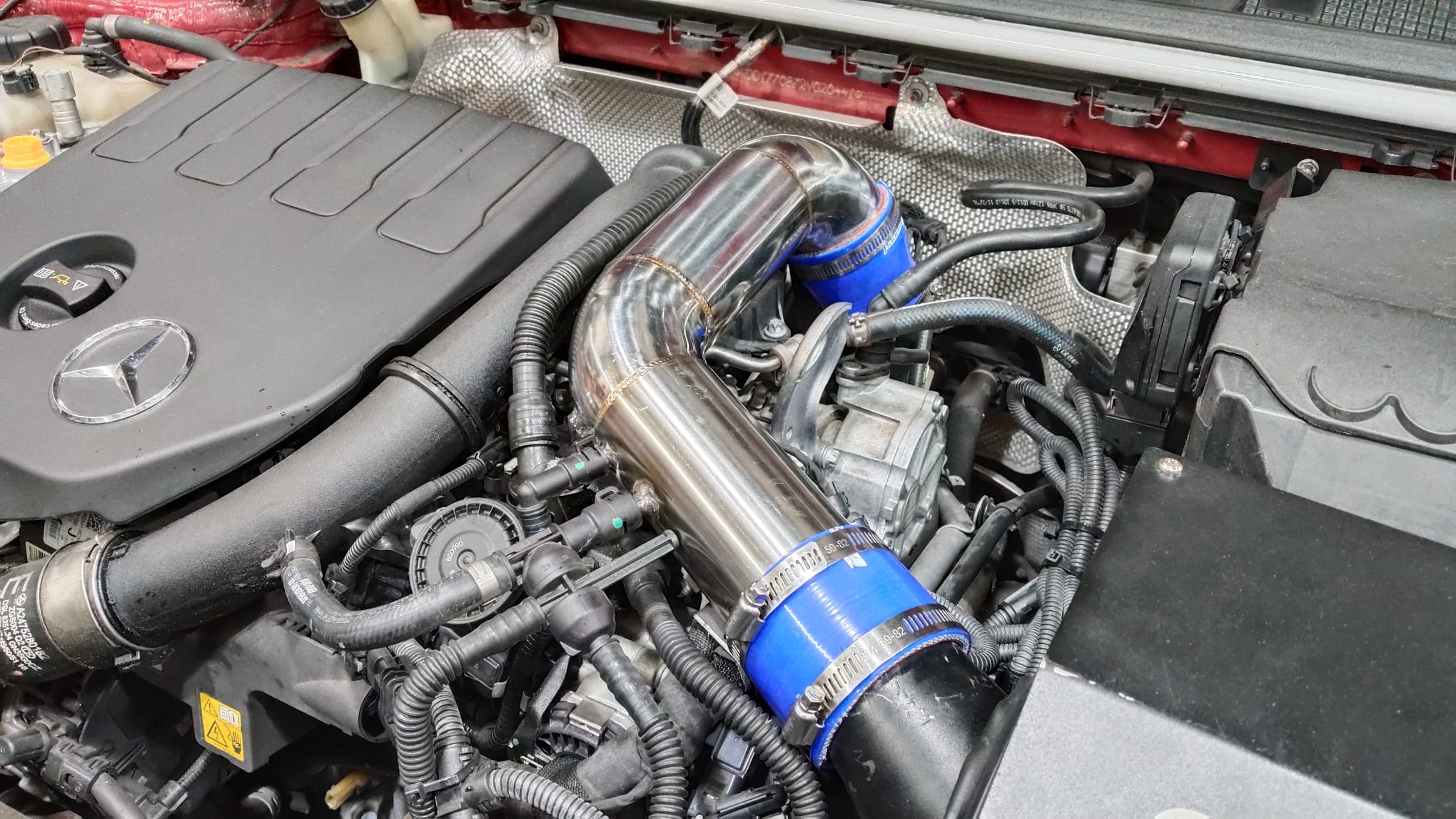 Custom TIG-welded stainless steel charge piping in a Mercedes engine bay